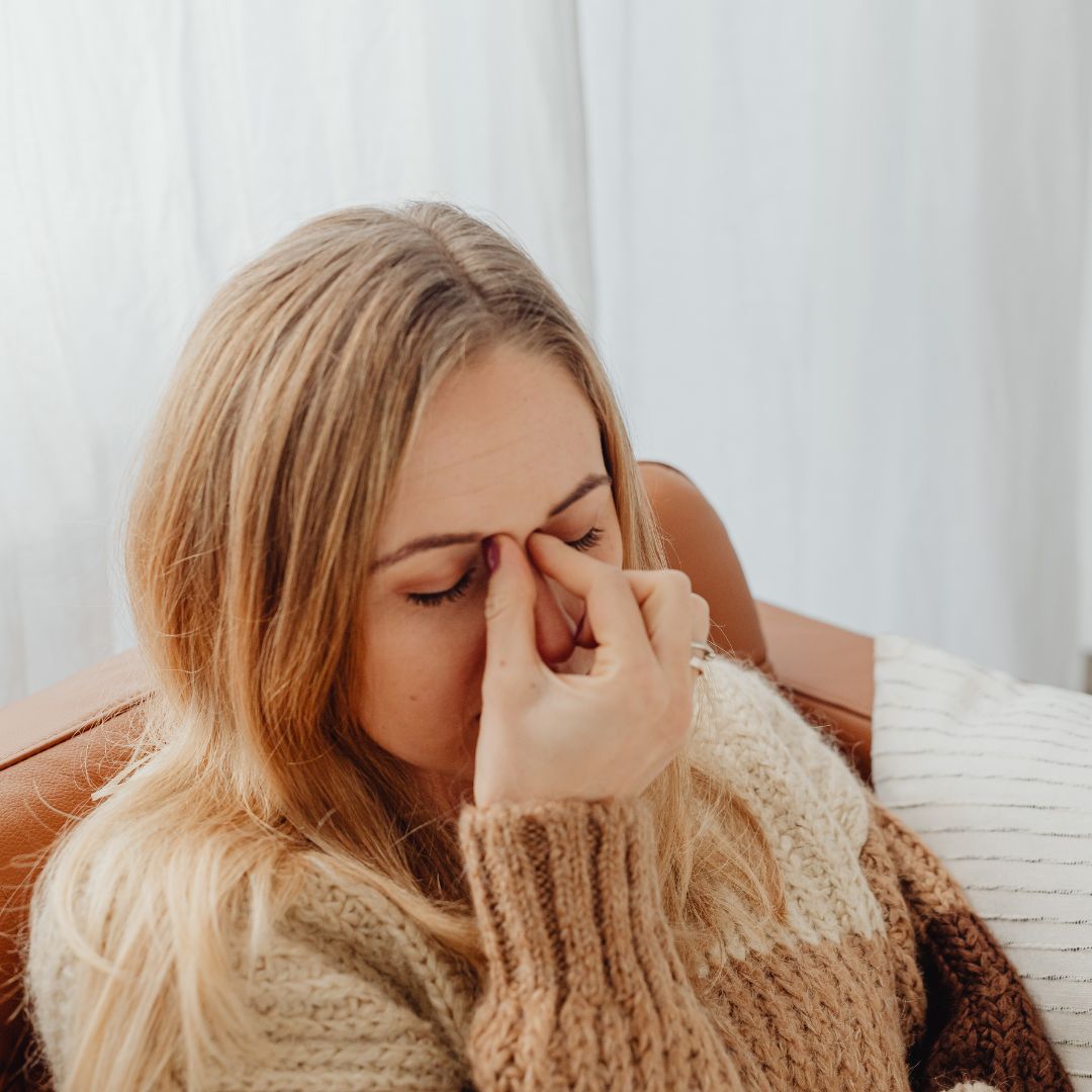 woman holding her nose